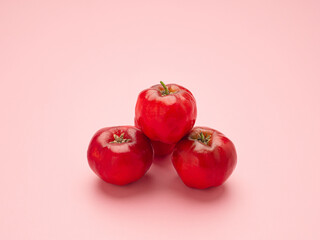 Close-up of three ripe red cherries isolated on a pink background. High vitamin C and antioxidant fruits. Concept of healthy fruits