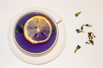 The mood color is blue - blue tea with lemon in a white mug, which stands on a white saucer and white tray. Contrast.