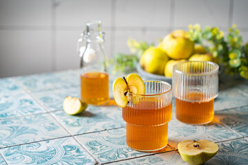 Healthy organic food. Apple cider or vinegar in a glass and fresh apples on a light background.