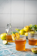 Healthy organic food. Apple cider or vinegar in a glass and fresh apples on a light background.