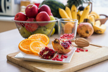 Healthy living and Vegan food. The fruits on the kitchen table were pomegranates, lemons, oranges, and apples.
