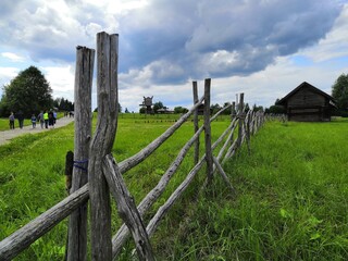 an old wooden fence for a home garden on a background of green grass in summer
