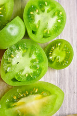 Naklejka na ściany i meble Green cut tomatoes on a gray board, top view, close-up.