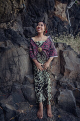 Balinese girl posing in nature and in a forest on Candidasa's offshore islands in Bali, dressed in a traditional costume. 