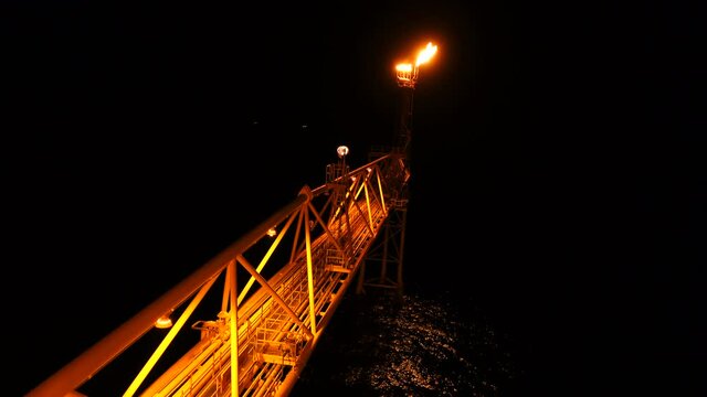 flare burning bridge of oil and gas platform or offshore platform while night time for oil and gas industry concept.