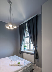 Fototapeta na wymiar Contemporary interior of bedroom in luxury apartment. Queen size bed against window.
