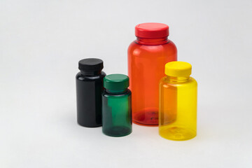 Multi colored transparent plastic pill jars on a white background. Isolated