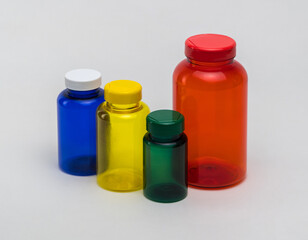 Multi colored transparent plastic pill jars on a white background. Isolated