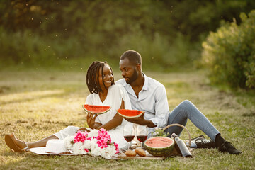 African american couple with watermelon on a meadow