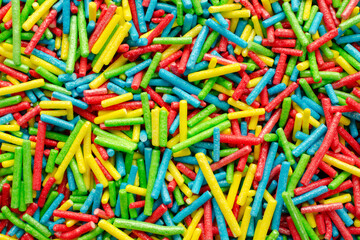 Fototapeta na wymiar Sugar paste for decoration, background, top view. Rainbow sprinkle for confectionery. Colorful confetti, background, top view. Pile of confectionery sprinkles, top view. Confectionery decor.