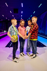 Children poses on the lane in bowling alley - obrazy, fototapety, plakaty
