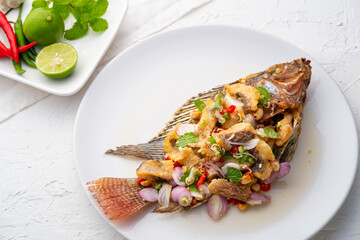 Fried Tilapia with spicy lemongrass salad.Deep fry tilapia fish in lime sauce mix with onion chilli Peanut and sliced lemongrass