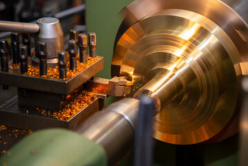 The lathe machine finishing cut the brass shaft parts by lathe tools.