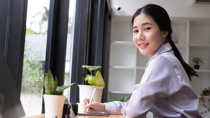 Asian woman hand holding pen stylus writing on digital tablet computer. close up