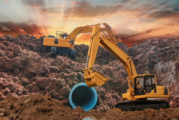 Two Crawler Excavator is digging in the construction site pipeline work on sunbeam background.