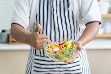Healthy living and Vegan food. Cooking vegan food. Male chef showing thumbs up and showing salad bowl.