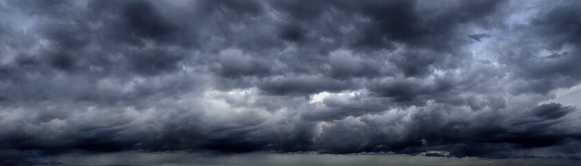 Banner Dramatic dark storm clouds black sky background. Dark thunderstorm clouds rainny season. Panorama Meteorology danger windstorm disasters climate. Dark cloudscape storm cloud with copy space.