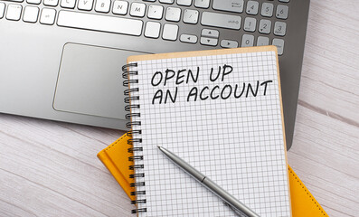 OPEN UP AN ACCOUNT text written on a notebook on the laptop,business