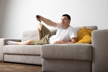 Young man relax at home sitting on sofa in room