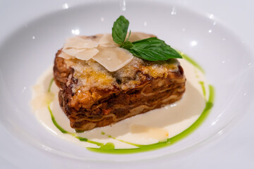 Closeup tasty traditional beef lasagne with cheese and basil leaves.