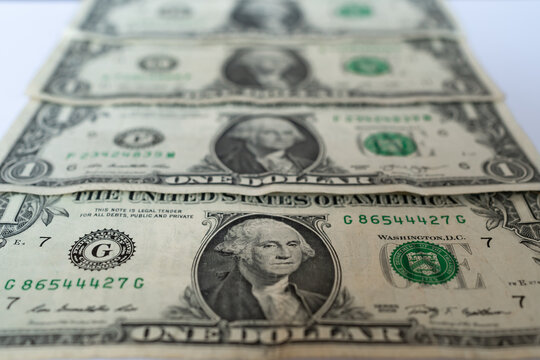 Dinero de los Estados Unidos de Am&eacute;rica,  4 billetes de un d&oacute;lar est&aacute;n colocados uno arriba del otro en la mesa.