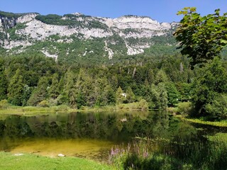reflections and views of Lake Cei in Trentino with the Dolomites as a background