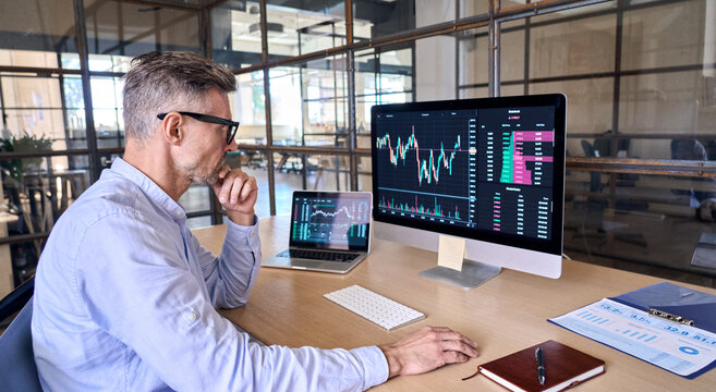 Mature Crypto Trader Investor Analyst Broker Using Pc Computer Analyzing Digital Cryptocurrency Exchange Stock Market Trading Graphs Report Thinking Of Investing Funds Risks Doing Global Analysis.