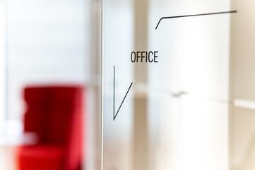 Transparent glass door in the office with the inscription OFFICE. A modern contemporary corporation
