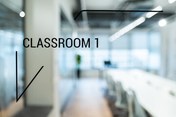 Glass door in the company with the inscription CLASSROOM 1, up close, and through the glass you can see the interior of the office