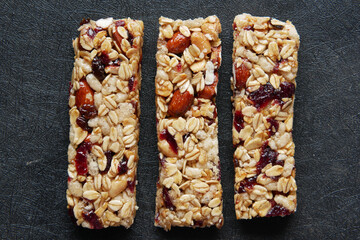 Almond , Raisin and oat protein bars on black background 