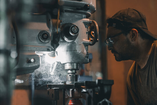 Hombre trabajando en un taller usando una maquina industrial