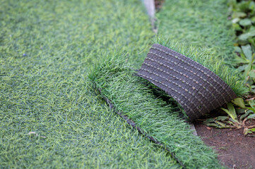 Green artificial turf used for covering sport arena or garden. Artificial grass are made by...