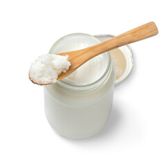 Single glass jar and a wooden spoon with coconut oil isolated on white background 