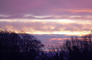 a powerful multi-coloured sky with the sunrise seemingly setting fire to swathes of cirrus cloud  