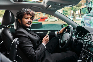 Indian businessman in a suit driving his car