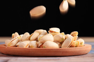 The pistachios are on the wooden board