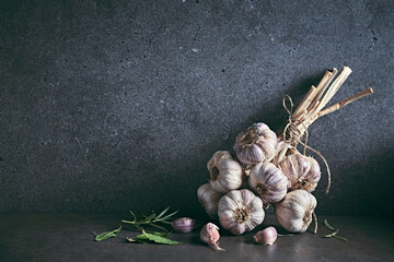 Bunch of organic garlic bulbs and herbs on rustic background. Copy space - 464859100