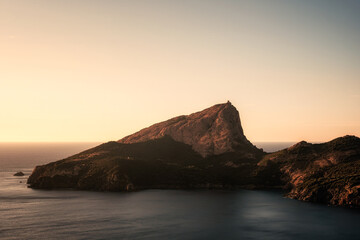 Evening sun on the Genoese tower of Tour de Turghiu sitting on Capo Rosso and the rugged west coast of Corsica