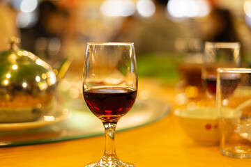 a glass of red wine on a dinner table