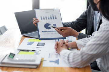 Close up view of business people investment advisors pointing at graph and analyzing financial report in meeting.