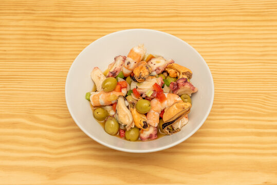 Seafood salpicon with olives, mussel meat, cooked prawns, sliced octopus, onion and minced peppers served in a Spanish tapas restaurant