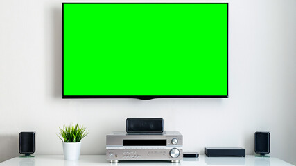 Tv with blank green screen in modern home interior in living room. Image ideal for advertising and marketing of online streaming platforms and services with shows and films