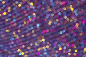 Blurred defocused Christmas magic background. Purple, yellow, blue, pink soft-focus lights. Colorful festive happy bokeh pattern.