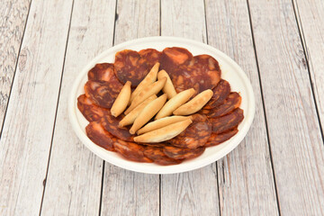 Spanish tapas of acorn-fed Iberian chorizo with peaks on a white takeaway plate