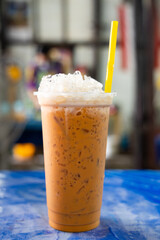 Glass of iced Thai milk tea on the table.