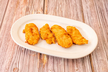 Spanish tapas of criadillas de toro battered with wheat flour, breadcrumbs and egg on wooden table
