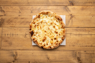 Baked pizza dough with mozzarella cheese on wooden table