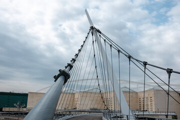 Obraz premium Steel structure walking bridge with train station in the background.