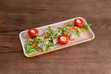 Chopped sardine tapa with cherry peppers stuffed with fresh cheese, parsley, arugula and chopped onion and tomato with olive oil