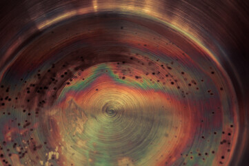 Macro photo of corrosion and oxidation of metal. Bottom of the pan with rainbow steel colouration....